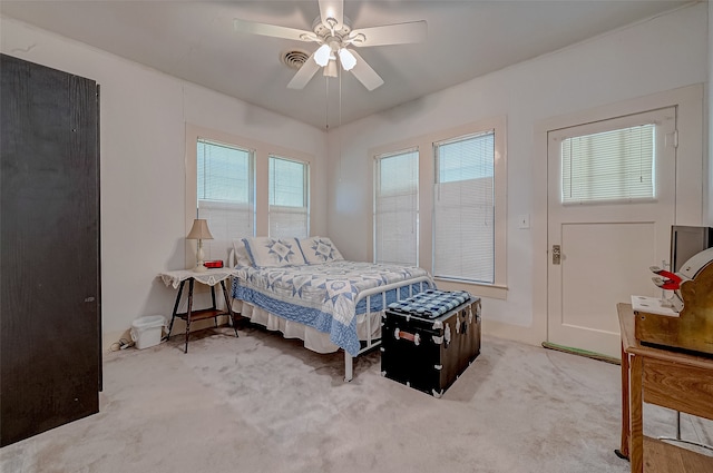 bedroom featuring multiple windows, ceiling fan, and carpet floors