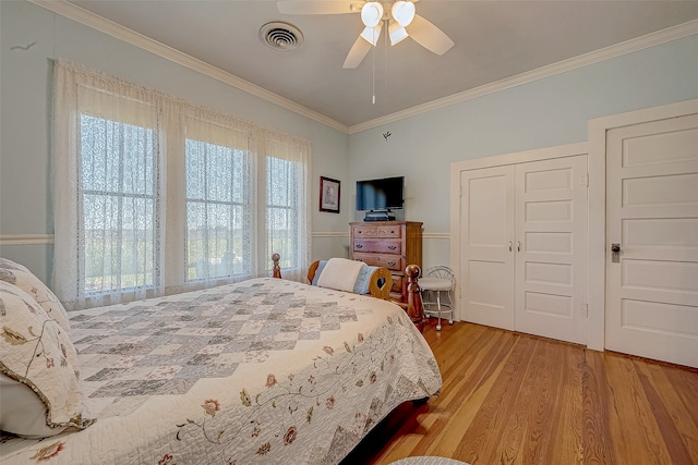 bedroom featuring light hardwood / wood-style floors, ceiling fan, and ornamental molding