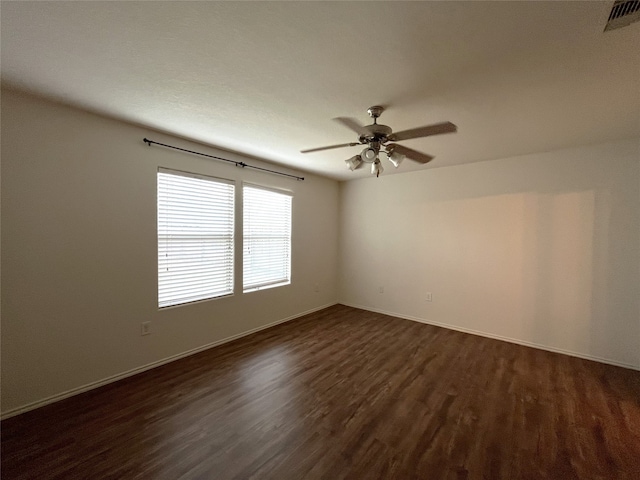 spare room featuring ceiling fan and dark wood-type flooring