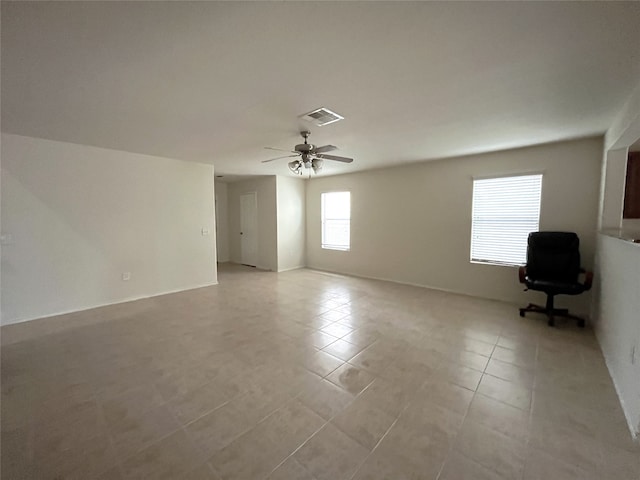 tiled spare room with ceiling fan