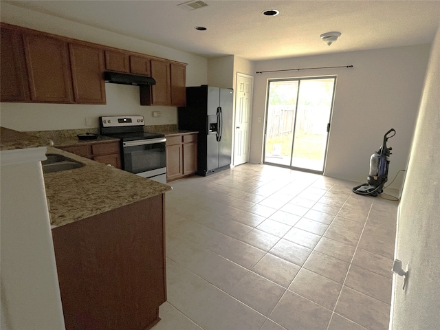 kitchen featuring ventilation hood, sink, refrigerator with ice dispenser, light tile patterned floors, and electric stove