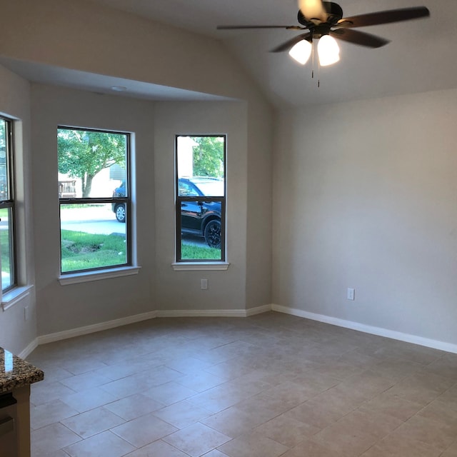 empty room featuring vaulted ceiling, ceiling fan, and light tile patterned flooring