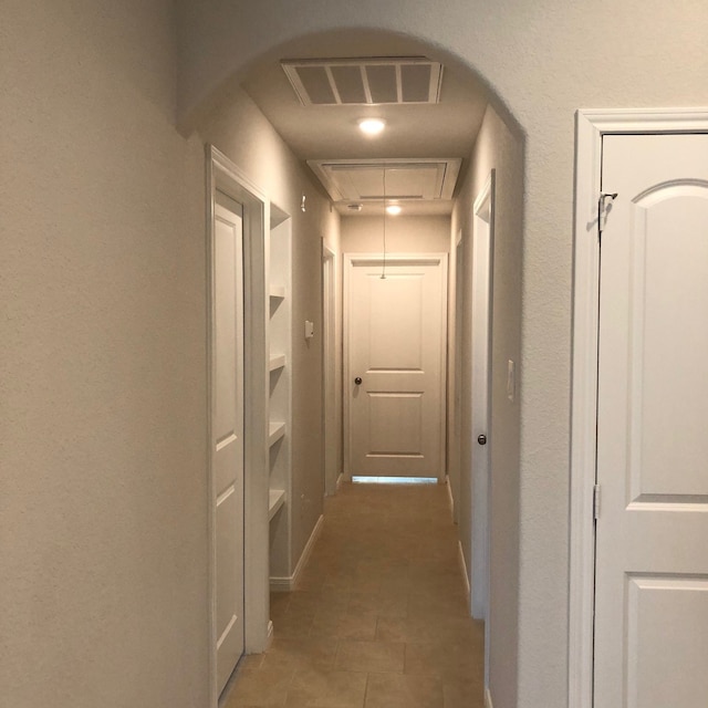 hall with dark tile patterned floors