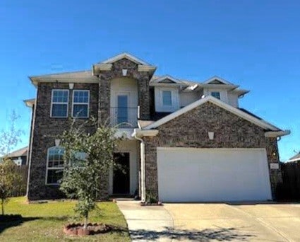 view of front facade featuring a garage, a balcony, and a front yard