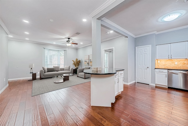 kitchen with hardwood / wood-style floors, white cabinets, and stainless steel dishwasher