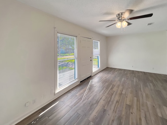 spare room with hardwood / wood-style flooring, ceiling fan, and a textured ceiling