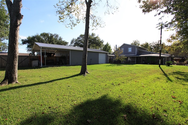 view of yard featuring a garage and an outbuilding