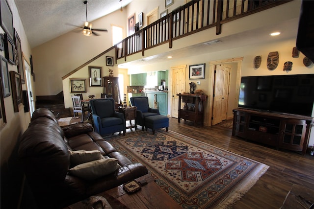 living room with a textured ceiling, dark hardwood / wood-style floors, high vaulted ceiling, and ceiling fan