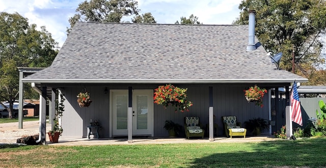 rear view of property with a lawn and french doors