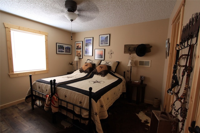 bedroom with a textured ceiling, ceiling fan, and dark wood-type flooring