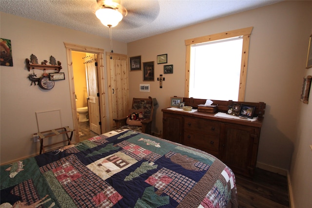 bedroom featuring a textured ceiling, ceiling fan, dark wood-type flooring, and ensuite bath