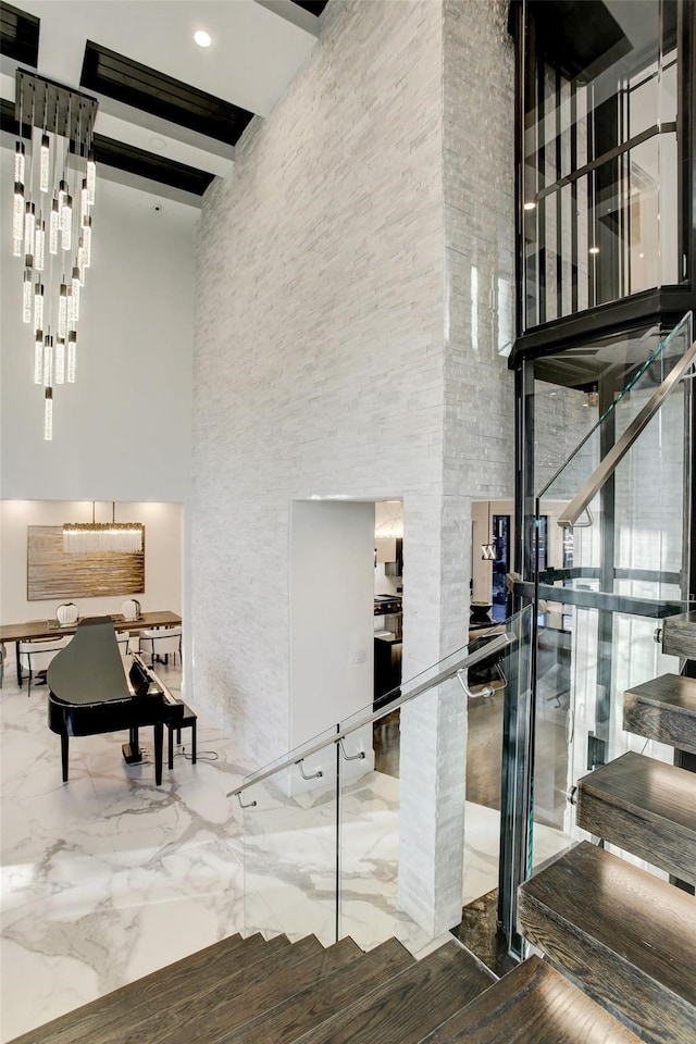 staircase featuring hardwood / wood-style floors, a towering ceiling, and beam ceiling