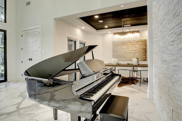 misc room featuring a tray ceiling, a towering ceiling, wooden ceiling, and an inviting chandelier