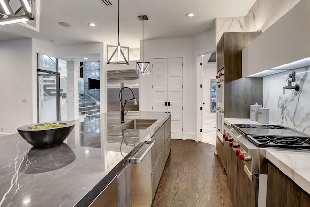 kitchen with decorative light fixtures, dark hardwood / wood-style flooring, sink, and appliances with stainless steel finishes