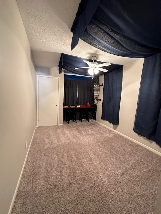 unfurnished bedroom featuring ceiling fan, carpet, and a textured ceiling