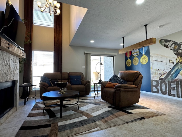 tiled living room featuring a fireplace, a textured ceiling, and an inviting chandelier