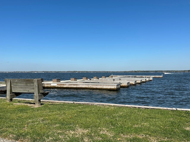 dock area with a yard and a water view