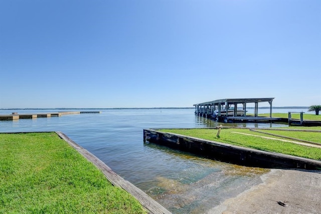 dock area with a water view and a yard