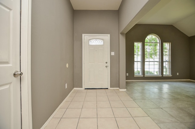 entryway featuring lofted ceiling and light tile patterned flooring