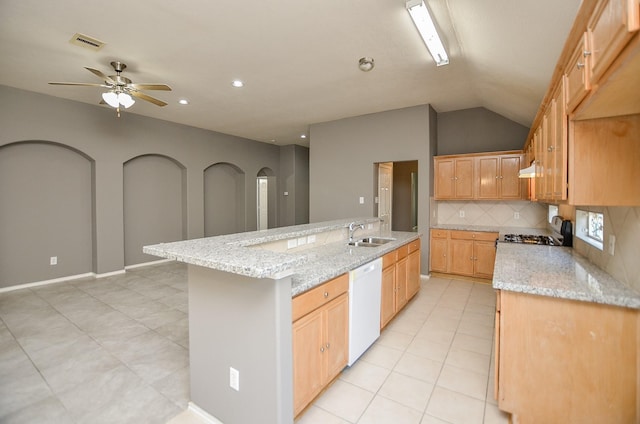 kitchen featuring a kitchen island with sink, white dishwasher, light stone countertops, and ceiling fan