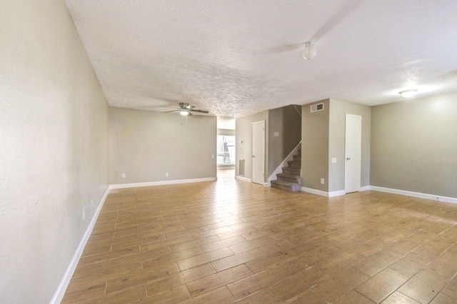 spare room featuring ceiling fan, wood-type flooring, and a textured ceiling