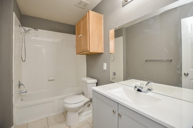 full bathroom with tile patterned flooring, vanity, tiled shower / bath combo, and toilet