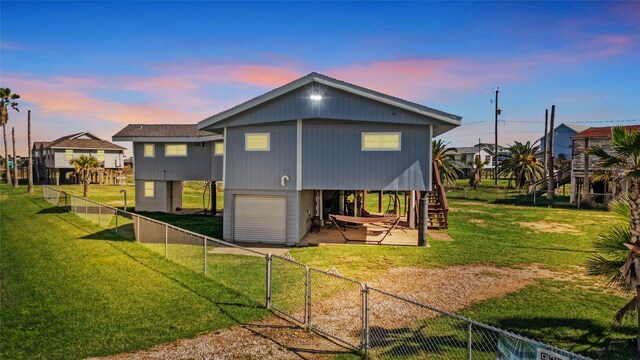 219 Fort Velasco Dr, Surfside Beach, TX 77541 - back of property at dusk with stairs, a gate, a garage, and a patio