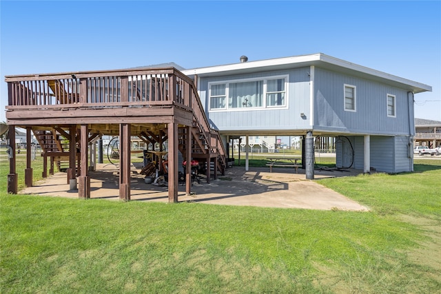 rear view of property with a lawn, a wooden deck, and a patio