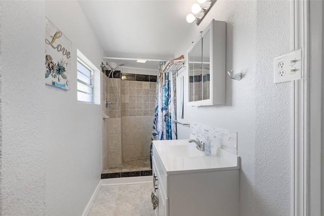 219 Fort Velasco Dr, Surfside Beach, TX 77541 - bathroom with a tile shower, vanity, a textured wall, tile patterned floors, and baseboards
