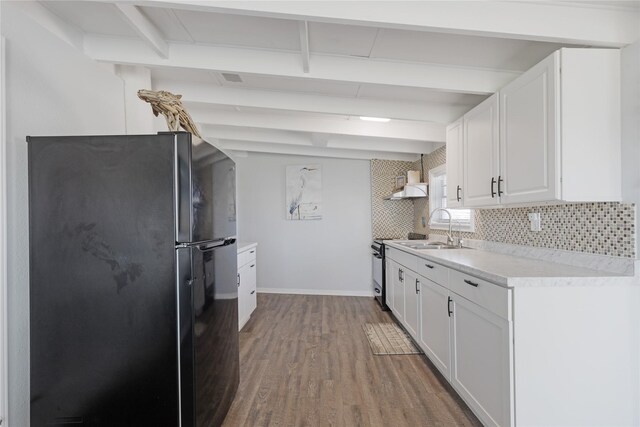 219 Fort Velasco Dr, Surfside Beach, TX 77541 - kitchen featuring freestanding refrigerator, wood finished floors, light countertops, white cabinets, and beam ceiling