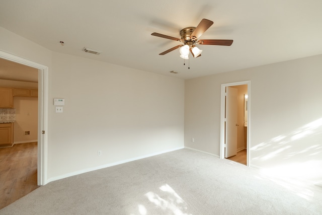 unfurnished room featuring light carpet and ceiling fan