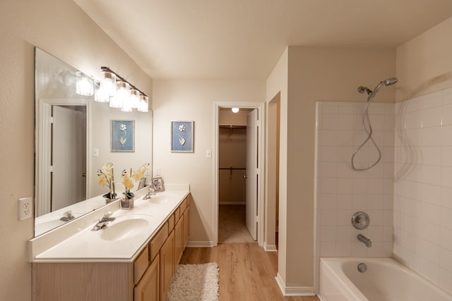 bathroom with vanity, tiled shower / bath combo, and hardwood / wood-style flooring