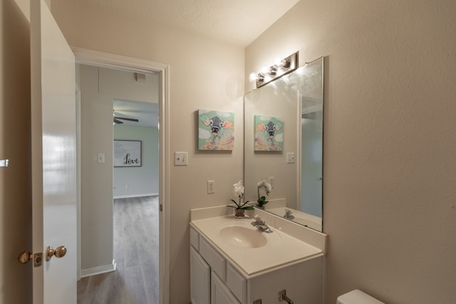 bathroom with vanity, ceiling fan, wood-type flooring, and a textured ceiling