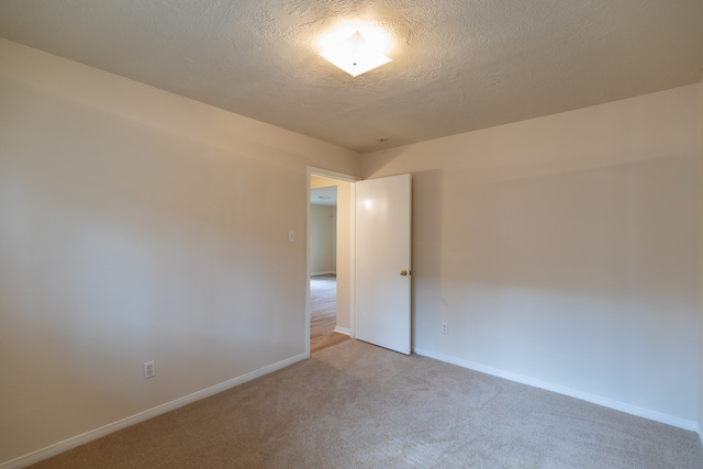 carpeted spare room with a textured ceiling