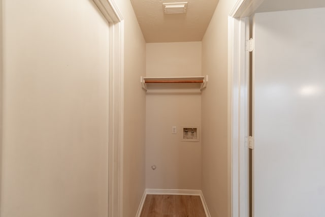 washroom featuring hookup for a washing machine, a textured ceiling, and hardwood / wood-style flooring