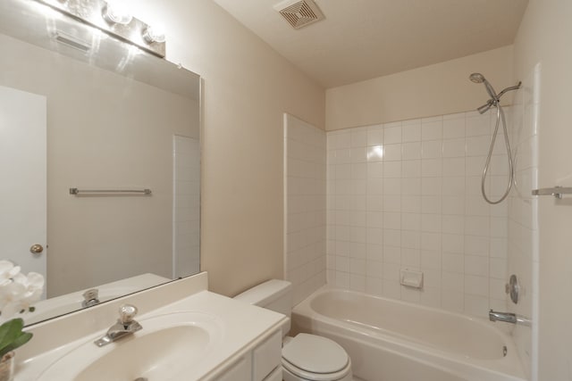 full bathroom featuring vanity, a textured ceiling, tiled shower / bath combo, and toilet