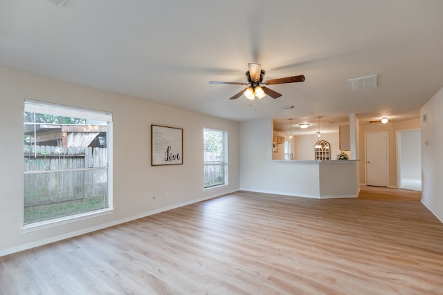 unfurnished living room with a wealth of natural light, ceiling fan, and light wood-type flooring