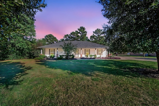 ranch-style home with a yard