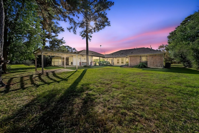 yard at dusk featuring a pergola