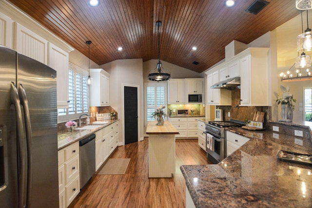 kitchen featuring white cabinetry, plenty of natural light, stainless steel appliances, and decorative light fixtures