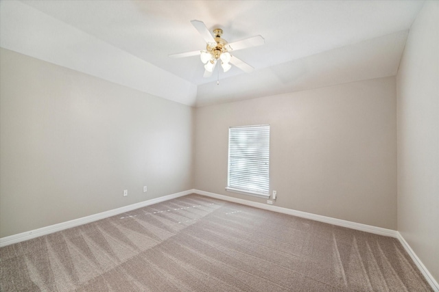 carpeted spare room featuring vaulted ceiling and ceiling fan