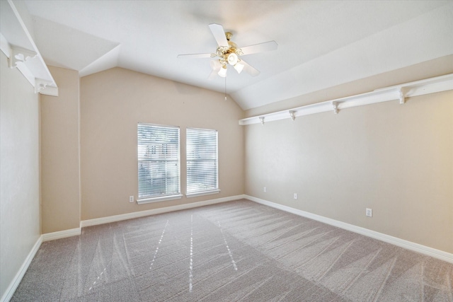 carpeted spare room featuring lofted ceiling and ceiling fan