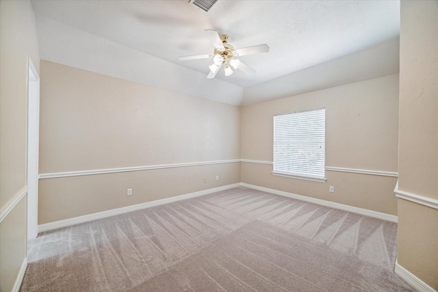 carpeted spare room featuring vaulted ceiling and ceiling fan