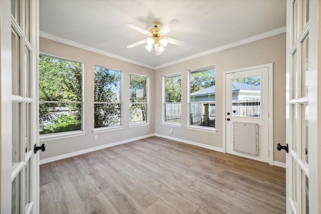 unfurnished sunroom featuring ceiling fan and french doors