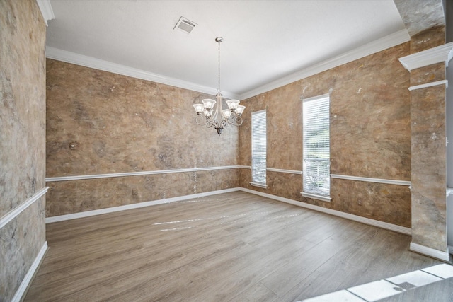 unfurnished room with ornamental molding, a chandelier, and hardwood / wood-style floors