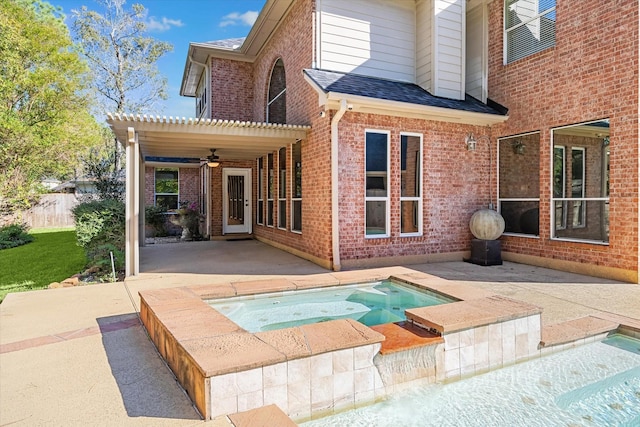 back of house featuring a patio area, ceiling fan, and an in ground hot tub