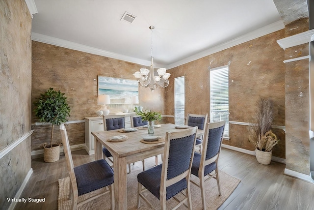 dining room featuring ornamental molding, a notable chandelier, and light hardwood / wood-style floors