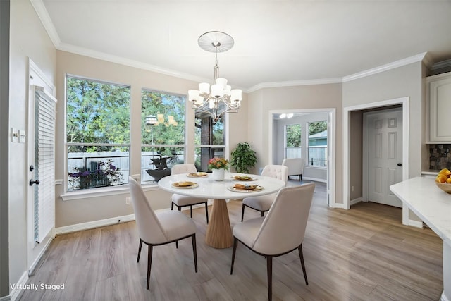 dining space featuring a notable chandelier, crown molding, and light hardwood / wood-style floors