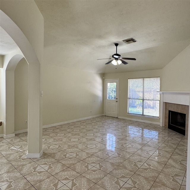 unfurnished living room featuring ceiling fan, a fireplace, and a textured ceiling