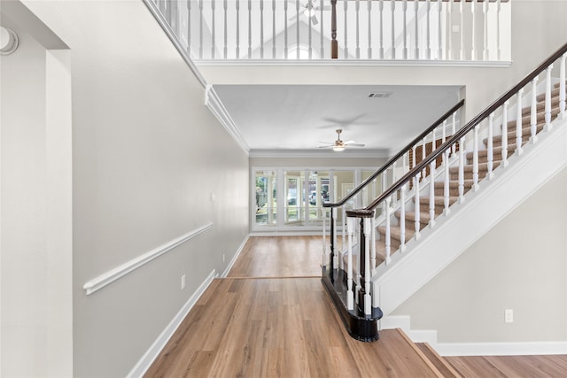 interior space featuring ceiling fan, crown molding, and wood-type flooring